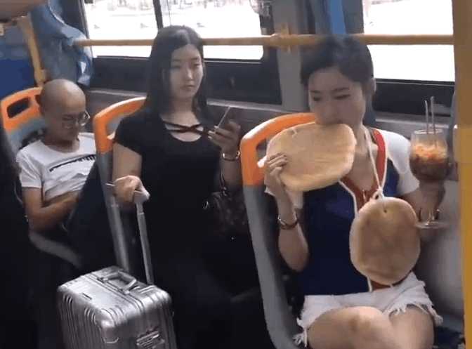 实拍女子公交车上脖子挂大饼：吃着高脚杯泡面（图）