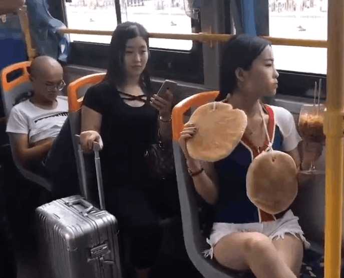 实拍女子公交车上脖子挂大饼：吃着高脚杯泡面（图）