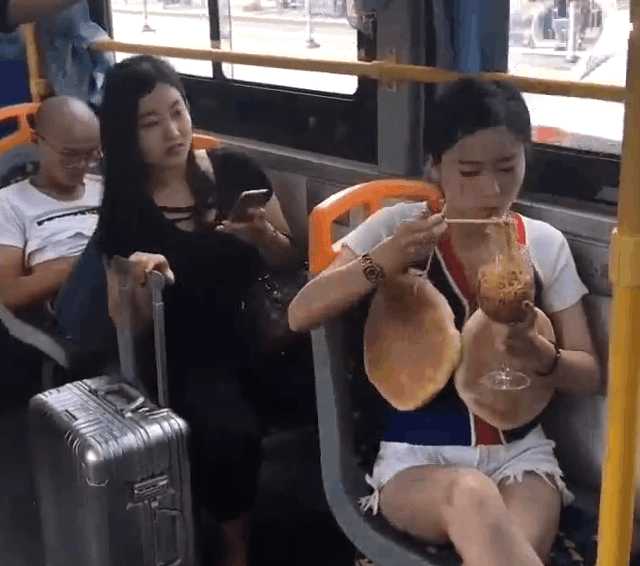实拍女子公交车上脖子挂大饼：吃着高脚杯泡面（图）