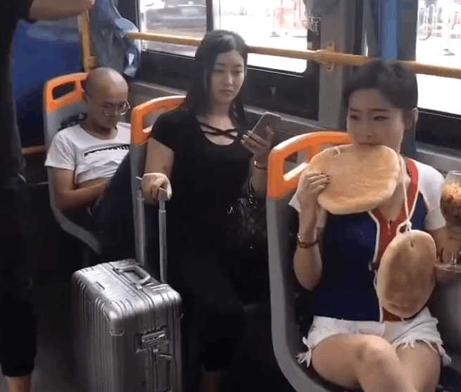 实拍女子公交车上脖子挂大饼：吃着高脚杯泡面（图）