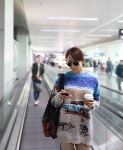 明星机场街拍：宽大毛衫搭配黑色长筒靴（图）