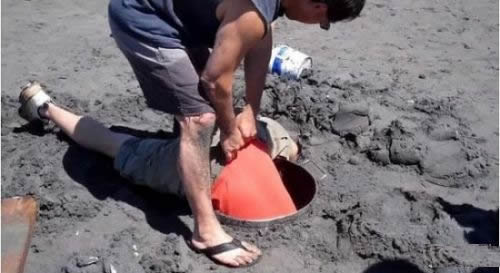 男子沙滩上挖洞 竟摸出这东西（组图）