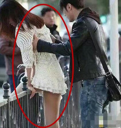 妹子穿裙子翻栏杆，一屁股坐到了柱子上，旁边的帅哥都看不下去了