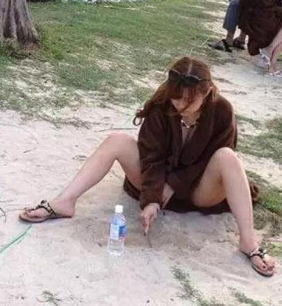 姑娘一个人坐在这里玩沙子呢