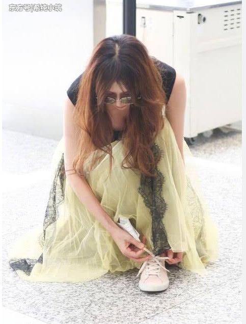 林志玲蹲地系鞋带露事业线：淡绿色的纱裙,甜美动人